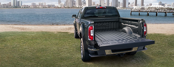 Image of the 2017 GMC Canyon small pickup truck from the rear with the tailgate open.