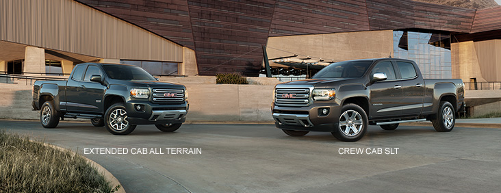 Image of the varying trim levles for the 2017 GMC Canyon small pickup truck with a building in the background.