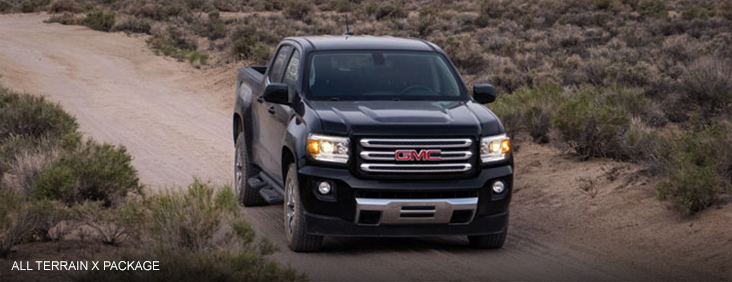 Image of the 2017 GMC Canyon All Terrain X driving down a road through a mountainous area.